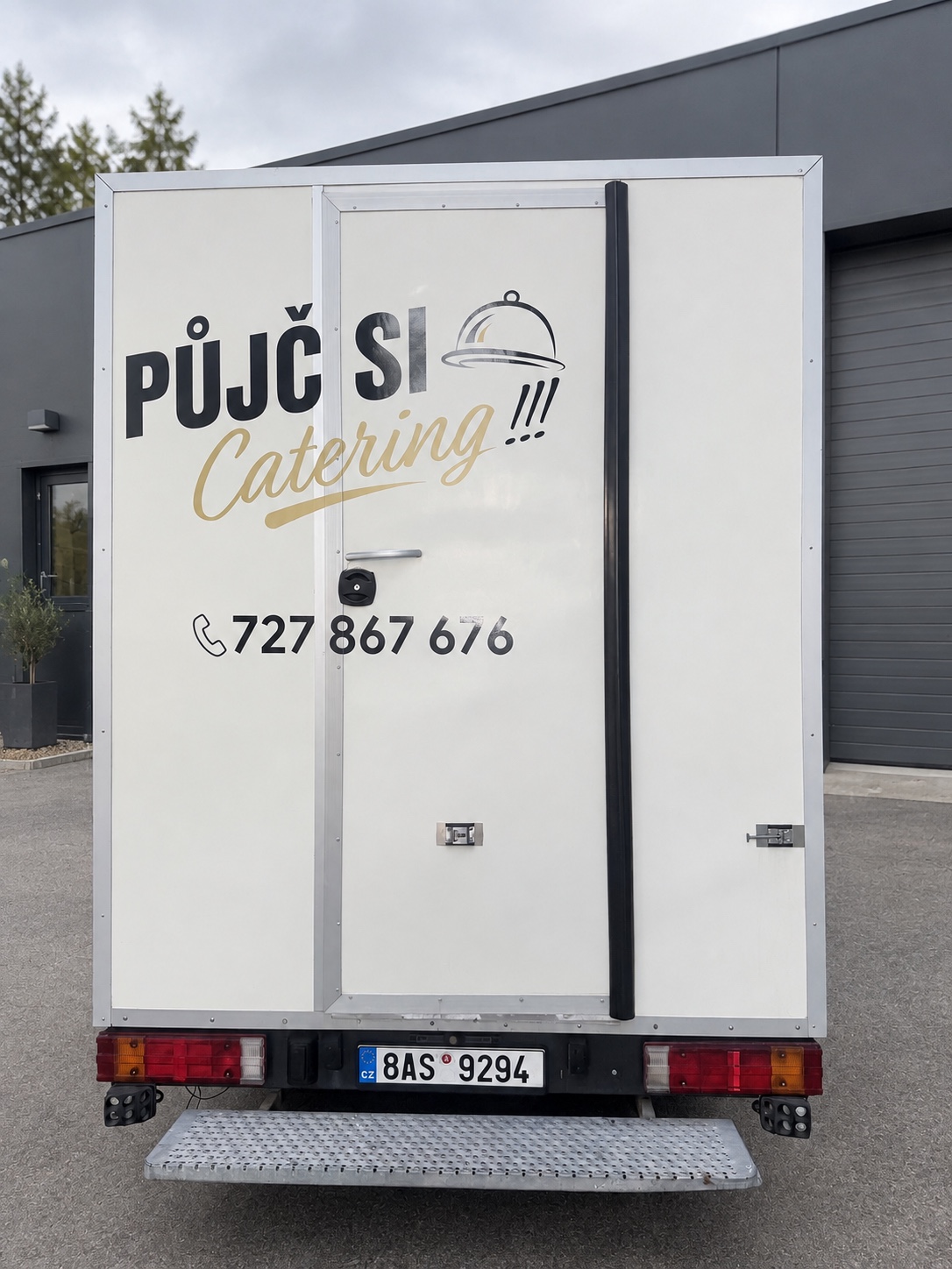 Zadní část cateringového vozu s logem Půjč si catering a schůdkem do kuchyně